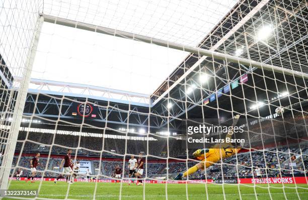 Ilkay Gundogan of Germany scores their sides second goal past Roberts Ozols of Latvia during the international friendly match between Germany and...