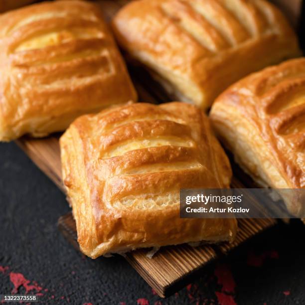 homemade baking. fresh baked puff pastry buns or sweet breads on black table background. square format. soft focus. close up shot - powder puff stock pictures, royalty-free photos & images