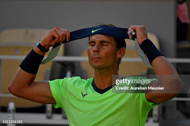 Rafael Nadal of Spain puts his sweat band back on in their mens singles fourth round match against Jannik Sinner of Italy during day nine of the 2021...