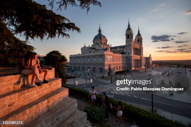 People sit near the Almudena Cathedral during sunset on June 07, 2021 in Madrid, Spain. Spain, the world's second most visited tourism destination,...