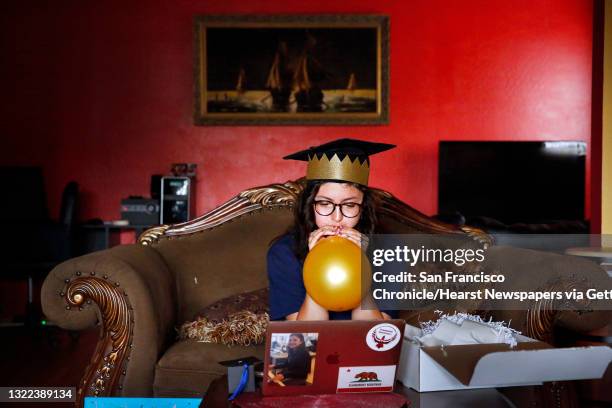 Melissa Hernandez Rivera blows up two gold balloons that arrived in a graduation gift box from Minds Matters San Francisco as she watches the Minds...