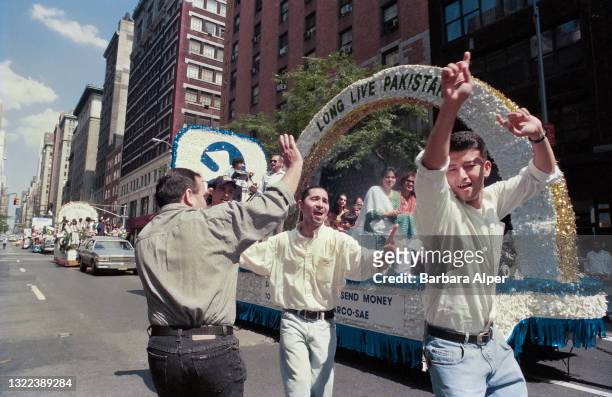 Men dance in the streets next to their "Long Live Pakistan" float celebrating the Pakistan Day Parade in New York City, August 25, 1996.