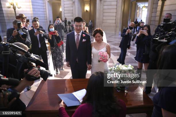 Perry Huang and his new wife Kathleen Li pick up their marriage certificate after they were married by San Francisco Mayor London Breed at San...