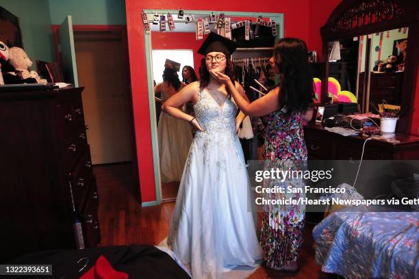 Melissa Hernandez Rivera , wears one of her prom dresses as she gets assistance from her mother Nancy Rivera Alfaro who curls her hair before she...