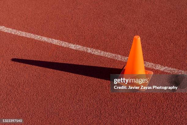 orange traffic cone placed on a sports court - traffic cone stock-fotos und bilder