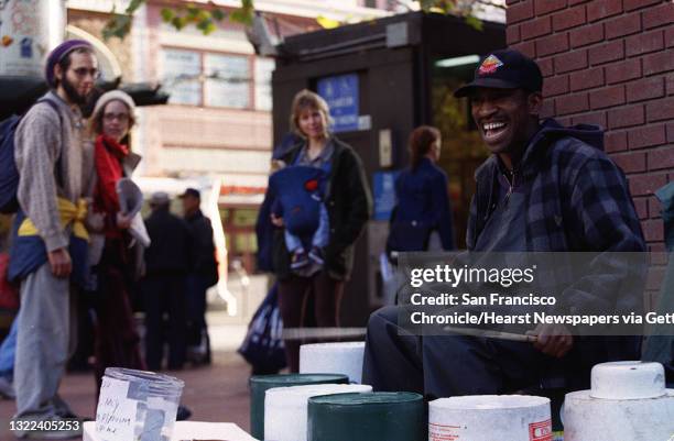 While LARRY HUNT drums on plastic buckets at the corner of Market and Stockton streets on Thursday afternoon, people stop to enjoy his music. Hunt...