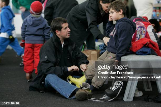 Soundscene_120_ls.JPG from left: Neil Kenney helps his son, Matthew Kenney put on his ice skates. Skaters enjoy the Yerba Buena Ice Skating Center on...