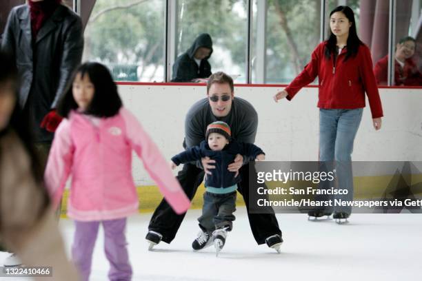Soundscene_418_ls.JPG Alan Blouin holds his son, Matisse Blouin , who received his first pair of skates from Santa on Christmas at the Yerba Buena...