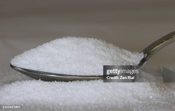 a heaped spoonful of granulated white sugar - granulated sugar stock pictures, royalty-free photos & images