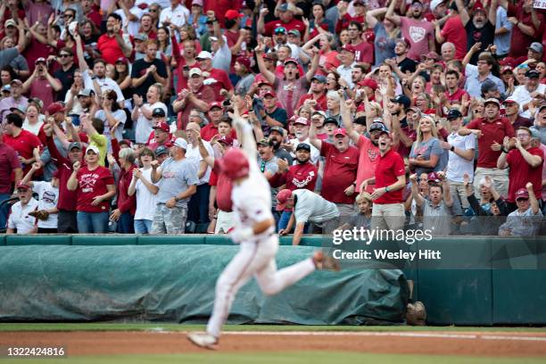 Catcher Casey Opitz of the Arkansas Razorbacks signals to the fans after hitting a home run against the Nebraska Cornhuskers at the NCAA Fayetteville...