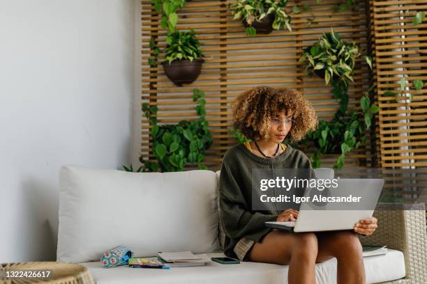 young woman using laptop in sustainable house - eco house stock pictures, royalty-free photos & images