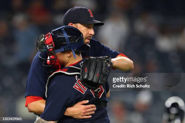 Closer Matt Barnes of the Boston Red Sox hugs catcher Christian Vazquez after defeating the New York Yankees 7-3 during a game at Yankee Stadium on...
