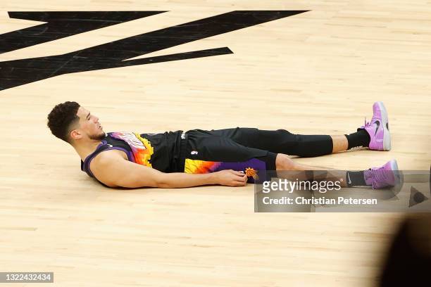 Devin Booker of the Phoenix Suns reacts to a three-point shot and foul from the Denver Nuggets during the second half in Game One of the Western...