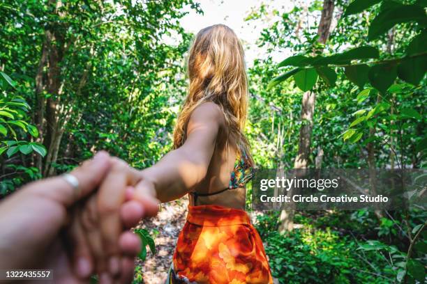 young woman leading boyfriend to tropical rainforest - following path stock pictures, royalty-free photos & images