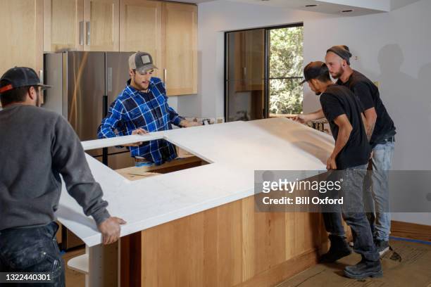 keuken verbouwen - mannen installeren aanrechtbladen - quartz stockfoto's en -beelden