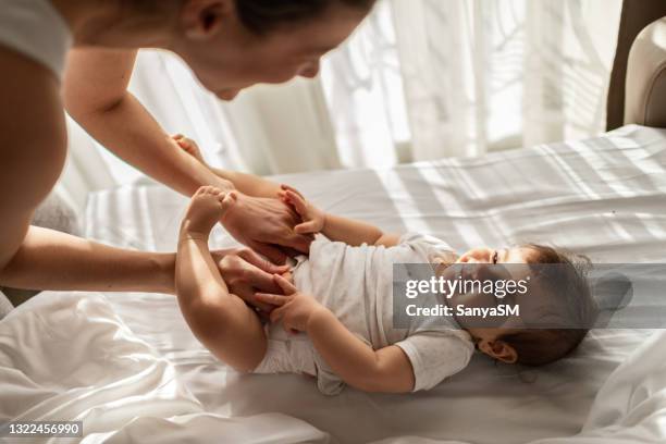 mother taking care of baby - nappy change stock pictures, royalty-free photos & images