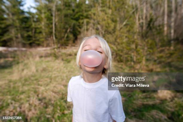 canada, ontario, kingston, portrait of boy blowing bubble gum in forest - bubble gum kid stock pictures, royalty-free photos & images