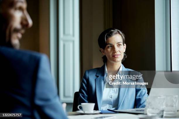 businesswoman with male colleague in meeting - businessmen meeting stock-fotos und bilder