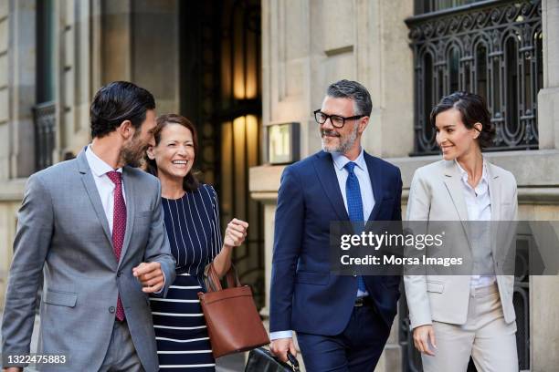 professionals are walking together outside hotel - four people walking stock pictures, royalty-free photos & images