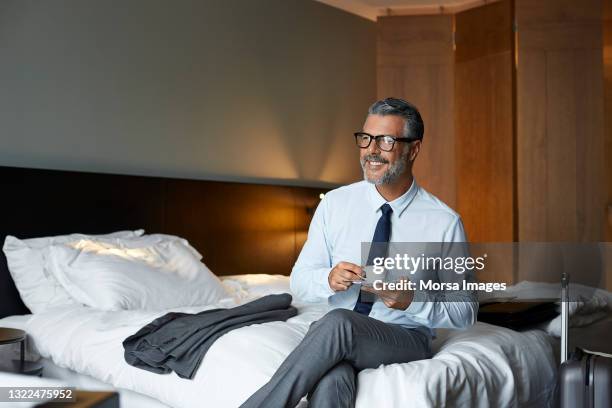 smiling businessman drinking coffee in hotel room - businessman hotel stock pictures, royalty-free photos & images