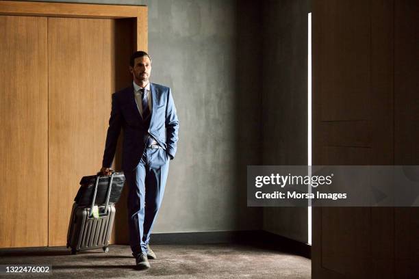 businessman walking with luggage in hotel - businessman hotel ストックフォトと画像