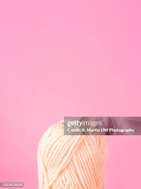 spool of yarn on pink background - ball of wool stock pictures, royalty-free photos & images