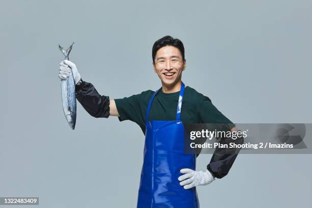 a male merchant holding fish - fisherman isolated stock pictures, royalty-free photos & images