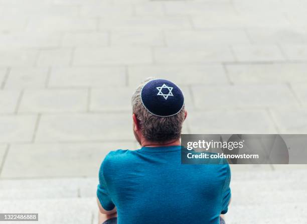 jüdischer mann trägt totenkopfmütze auf der stadtstraße - judenstern stock-fotos und bilder