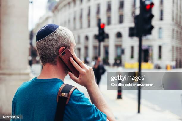 jewish man wearing skull cap on city street - skull cap stock pictures, royalty-free photos & images