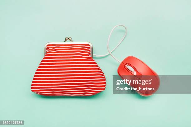 still life of a wallet and red computer mouse on green background - green purse stockfoto's en -beelden