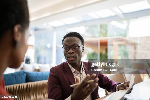 real estate agent or finance advisor doing a meeting with customer at home - african at the bank stock pictures, royalty-free photos & images