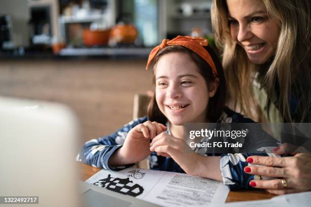 mother helping special needs daughter during homeschooling - mental disability stock pictures, royalty-free photos & images