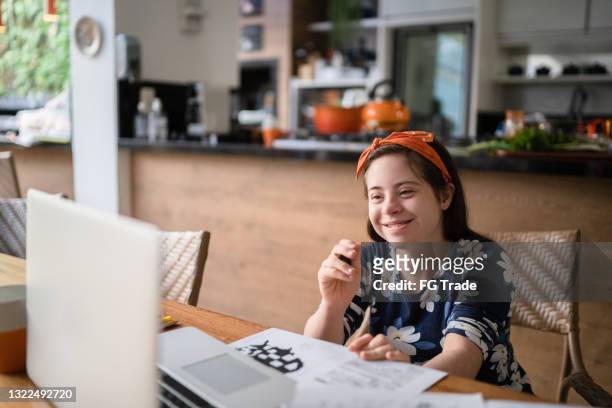 special needs girl watching video class on laptop at home - children only stock pictures, royalty-free photos & images