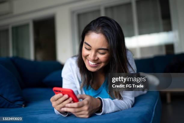 happy young woman using smartphone at home - smartphone video stock pictures, royalty-free photos & images