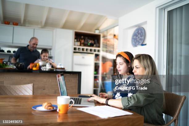 mother working at home with daughter with special needs - work life balance home stock pictures, royalty-free photos & images