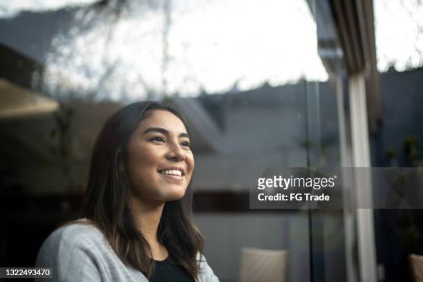 young woman contemplating at home - positieve emotie stockfoto's en -beelden
