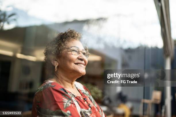 senior woman contemplating at home - oud stockfoto's en -beelden