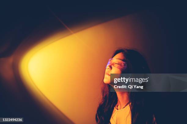 woman wearing augmented reality standing in yellow spotlight - person spot light photos et images de collection