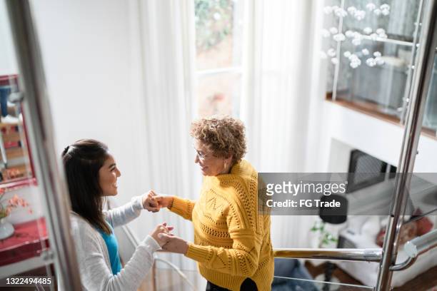 nurse supporting senior patient walking or moving up the stairs at home - patient support stock pictures, royalty-free photos & images