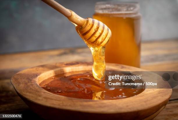 close-up of honey in jar on table - honinglepel stockfoto's en -beelden