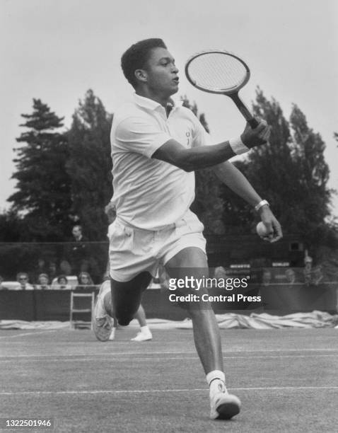 Richard Russell of Jamaica reaches to make a running forehand return to Stanley Matthews of Great Britain during their Men's Singles First Round...