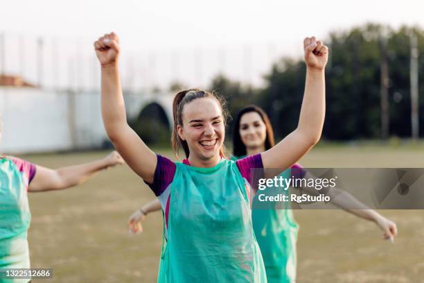 happy girl from a rugby team warming up with her teammates - youth club stock pictures, royalty-free photos & images