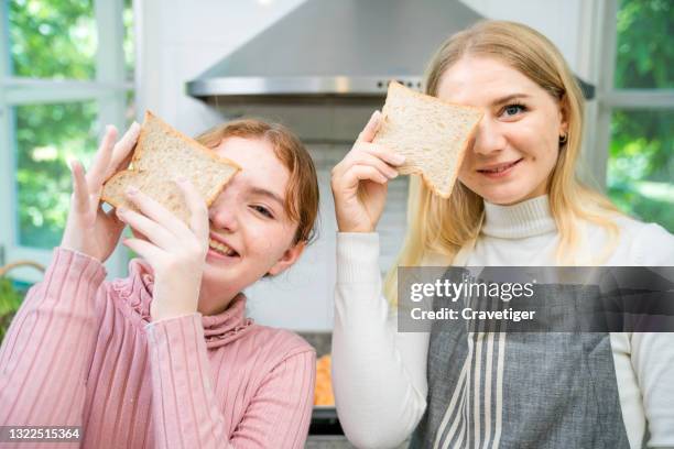 caucasian mom and daughter making  prepare sandwich in the kitchen room for breakfast at home happy family lifestyle. - making a sandwich stock pictures, royalty-free photos & images