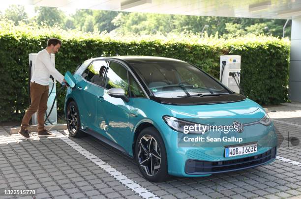 Volkswagen employee demonstrates the charging of a Volkswagen ID.3 electric car outside the "Gläserne Manufaktur" production facility on June 08,...