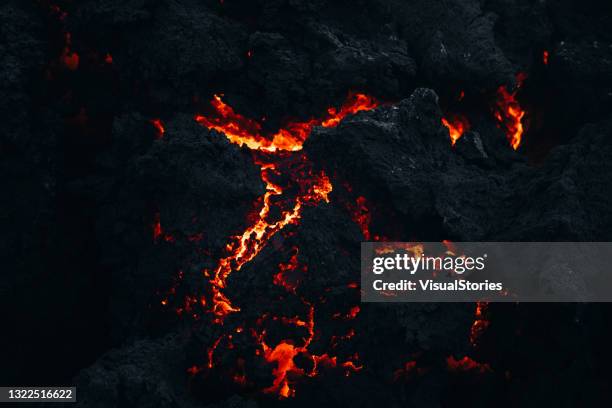 close-up view of the fresh melting burning lava at fagradalsfjall volcano eruption site, iceland - volcanic rock stock pictures, royalty-free photos & images