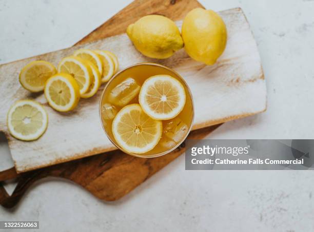 fresh and delicious top down image of a drink garnished with lemon slices and ice - citrus limon foto e immagini stock