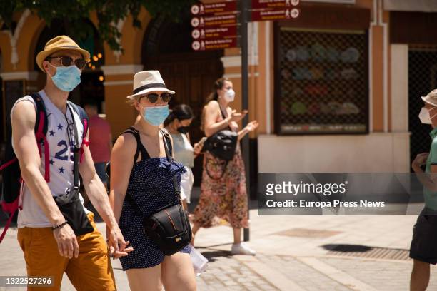 Tourists stroll through the center of Seville equipped with hats, fans and water bottles because the Andalusian capital has exceeded 40 ° C and...