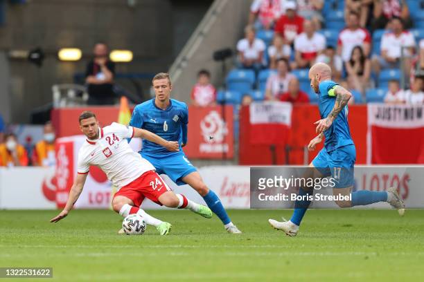 Jakub Swierczok of Poland is challenged by Brynjar Ingi Bjarnason and Aron Gunnarsson of Iceland during the international friendly match between...