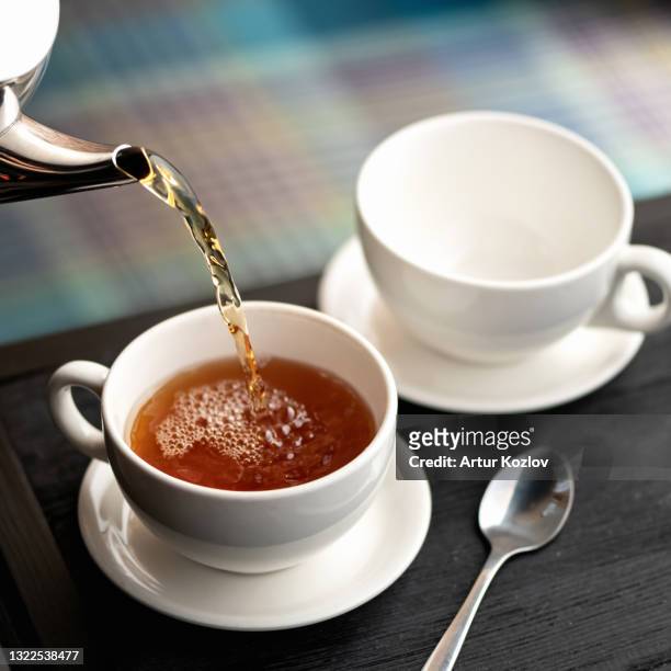 aromatic hot black tea pouring into white cups from metal kettle. good morning concept. soft focus - ceremony stock pictures, royalty-free photos & images