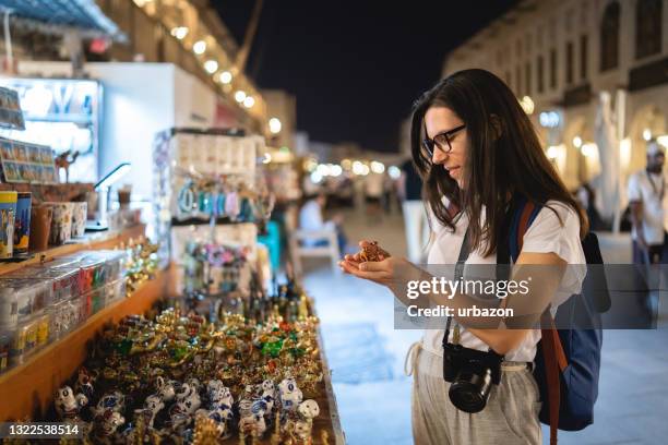 frau beim einkaufen auf dem straßenmarkt in doha - night market stock-fotos und bilder